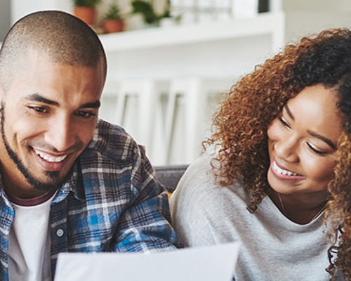 Couple on sofa looking at a letter - Insurance Header
