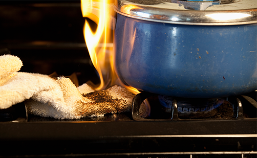 Saucepan on gas stove and cloth has caught fire