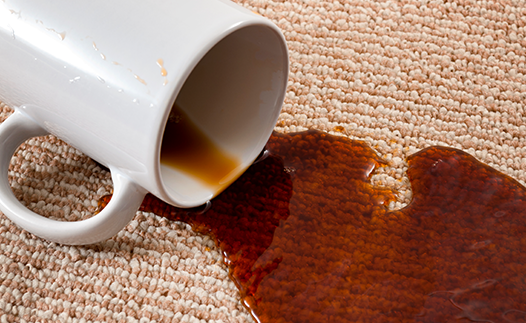 Mug of black coffee spilt onto carpet