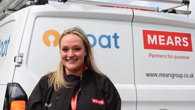 Image shows a female Mears operative standing in front of a Mears van