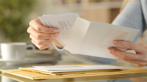 Person opening a letter, with others unopened