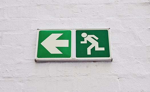 Fire exit sign on white brick wall