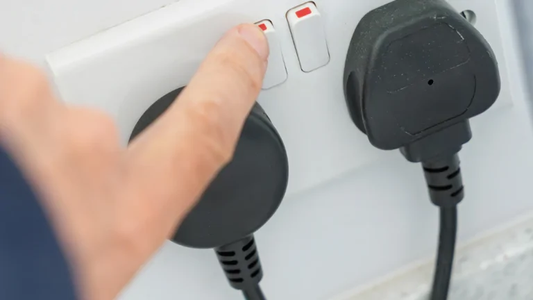 Person switching off electrical switch on double plug socket