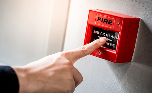Person pressing red fire alarm