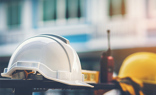 Construction site with hard hats, spirit level and walkie talkie