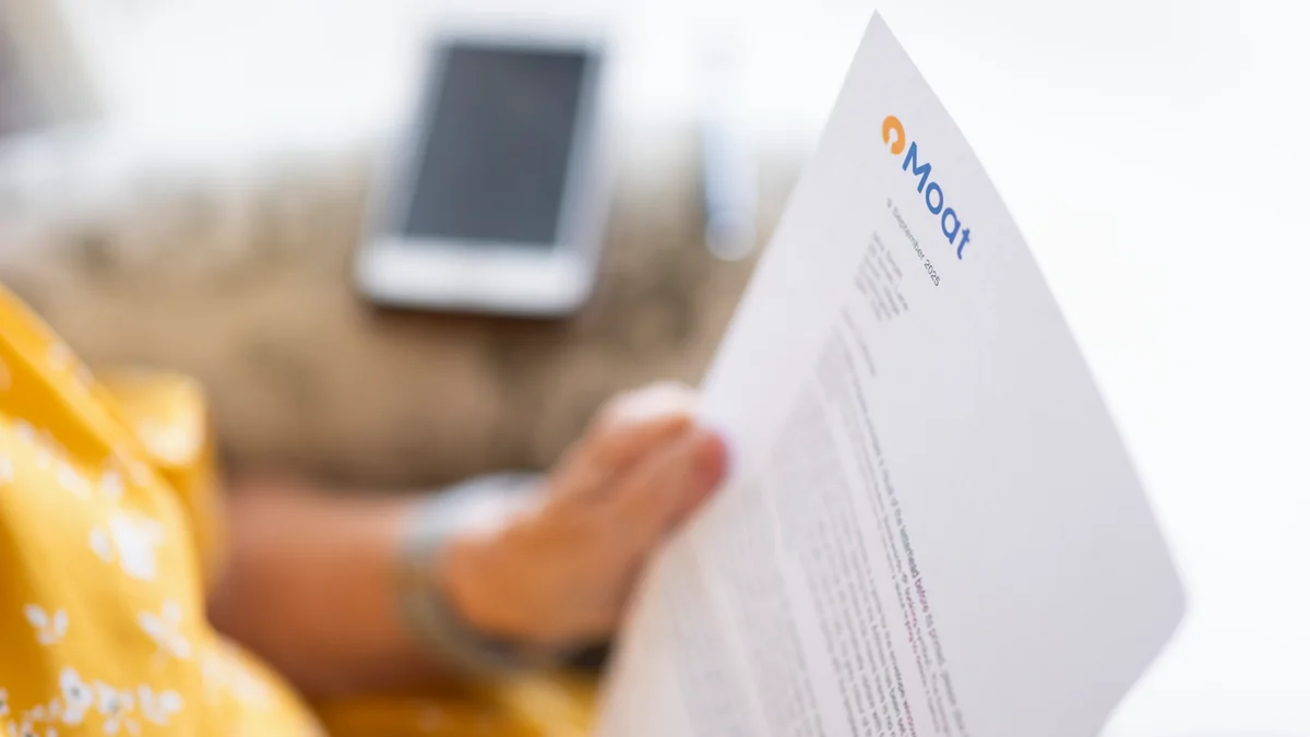 Image shows a woman reading a letter from Moat
