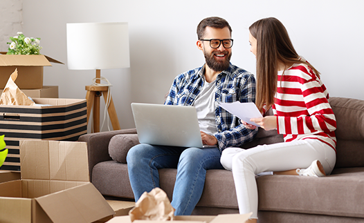 Couple on sofa with laptop and paperwork