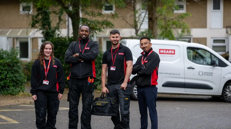 Image of four Moat operatives standing outside by a van