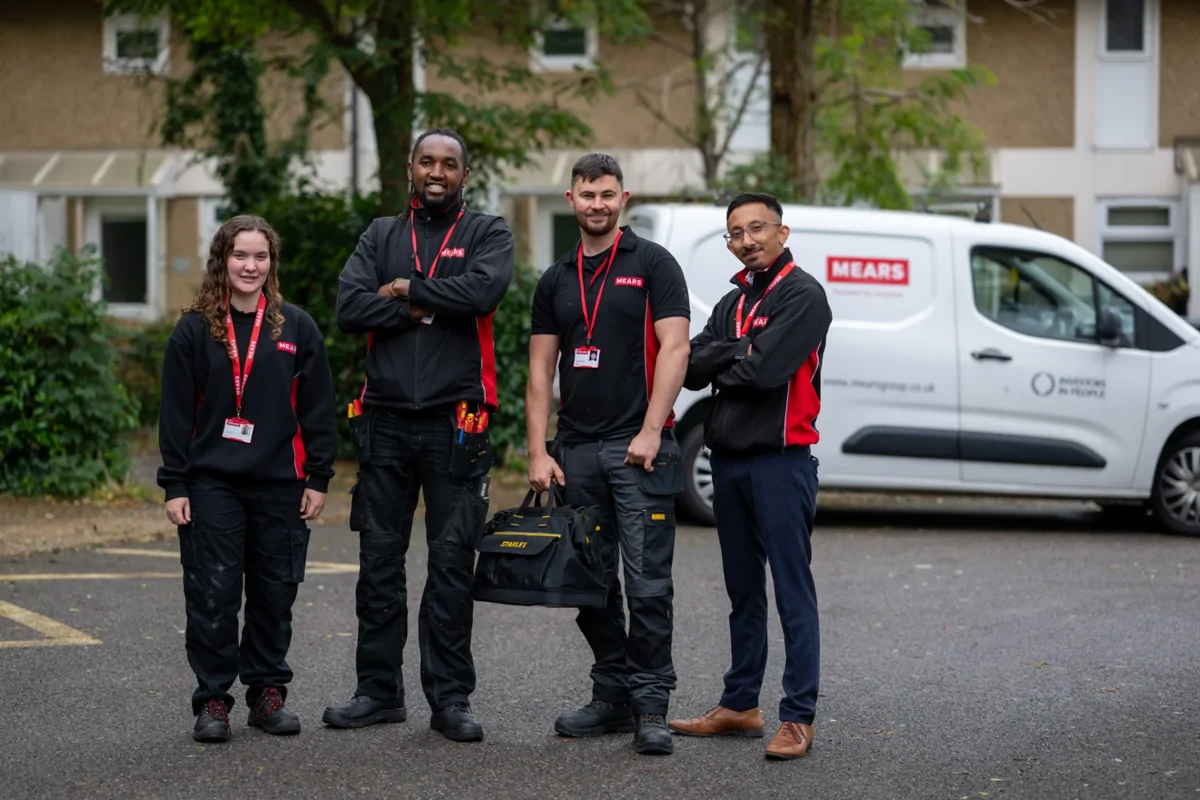 Image of four Moat operatives standing outside by a van